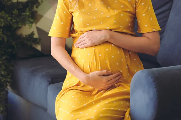 Mooie zwangere vrouw zittend op de bank, close up — Stockfoto