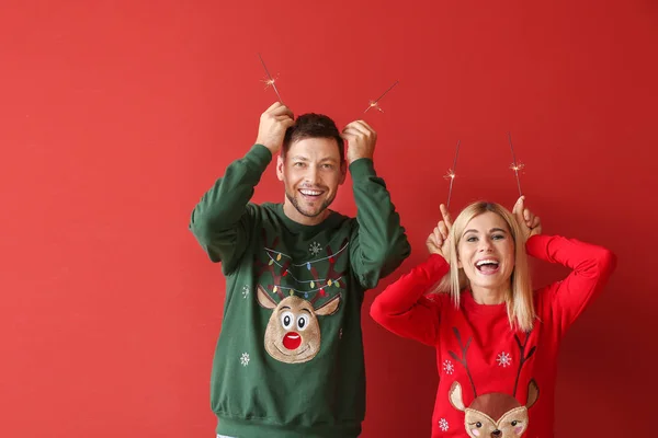 Lyckligt par med Christmas tomtebloss på färg bakgrund — Stockfoto