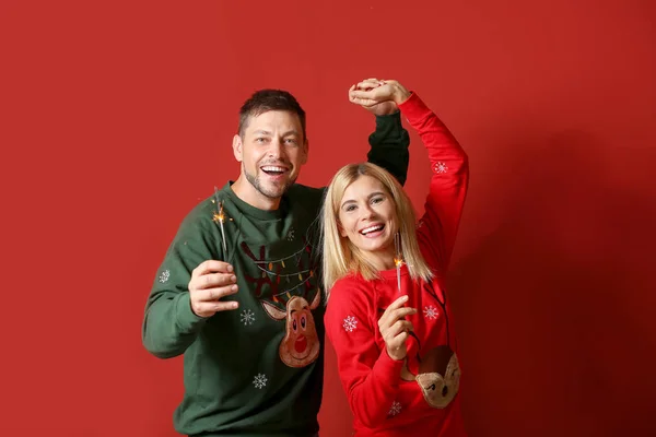 Щаслива пара з різдвяними блискітками на кольоровому фоні — стокове фото