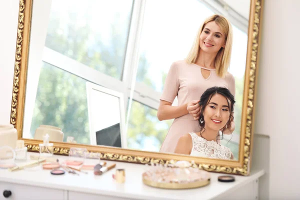 Professional hairdresser working with young Asian bride at home — Stock Photo, Image