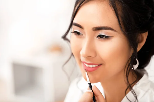 Professional makeup artist working with young Asian bride at home — Stock Photo, Image