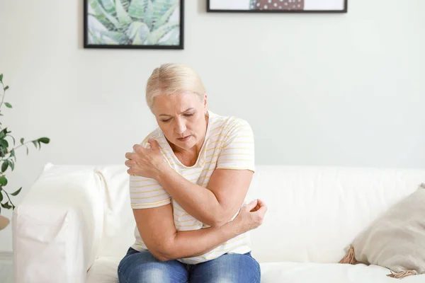 Mature woman suffering from pain in shoulder at home — Stock Photo, Image