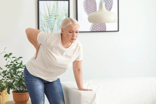 Mature woman suffering from back pain at home — Stock Photo, Image