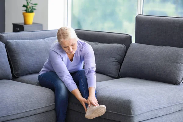 Mature woman suffering from pain in leg at home — Stock Photo, Image