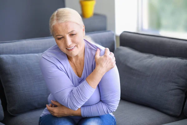 Starší žena trpí bolestí v rameni doma — Stock fotografie