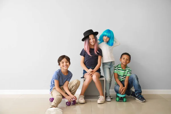 Snygga små barn med skateboard nära ljus vägg — Stockfoto
