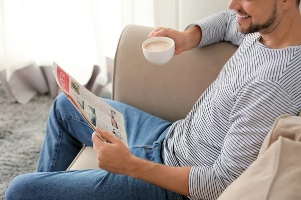 Hombre con periódico y taza de café relajándose en casa —  Fotos de Stock