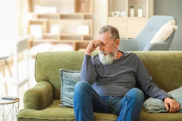 Hombre mayor que sufre de dolor de cabeza en casa — Foto de Stock