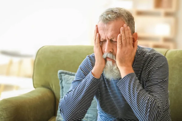 Senior man suffering from headache at home — Stock Photo, Image