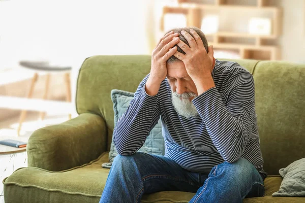 Senior man suffering from headache at home — Stock Photo, Image