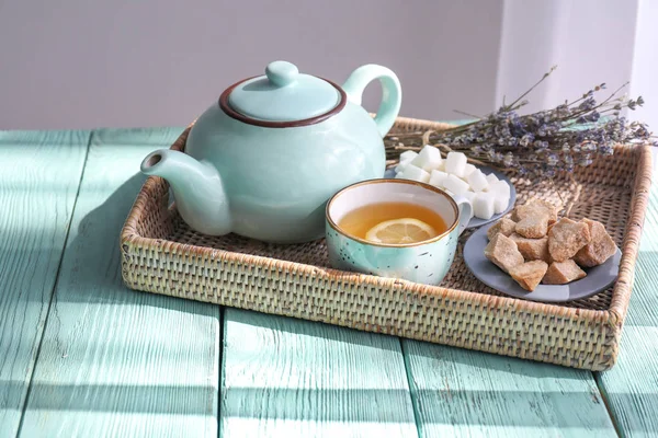 Tray with teapot and cup of hot beverage on wooden table — Stock Photo, Image