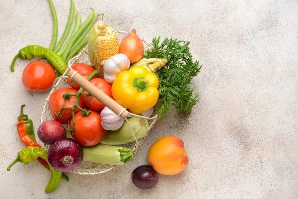 Basket with many healthy vegetables and fruits on grey background — Stock Photo, Image