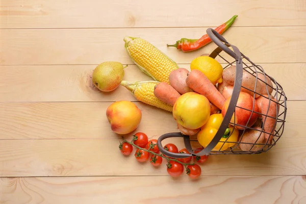 Basket with many healthy vegetables and fruits on wooden background — Stock Photo, Image