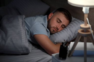 Genç adam yatakta gece uyku