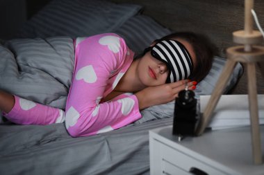 Genç kadın geceleri yatakta uyuyor.