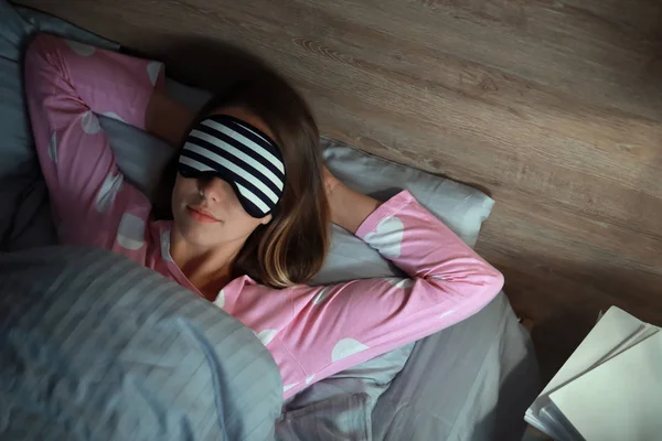 Genç kadın geceleri yatakta uyuyor.
