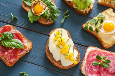 Tahta masada farklı lezzetli sandviçler.