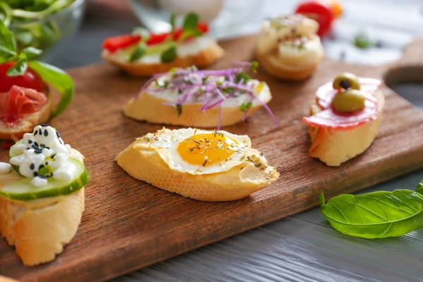 Different tasty sandwiches on wooden board — Stock Photo, Image