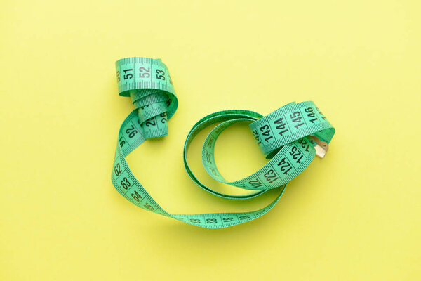 Measuring tape on color background