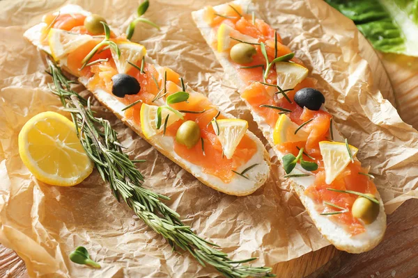 Lekkere broodjes met zalm op perkament — Stockfoto