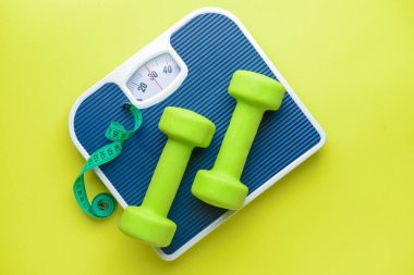 Pullar, halterler ve renkli arka planda mezura. Kilo verme konsepti
