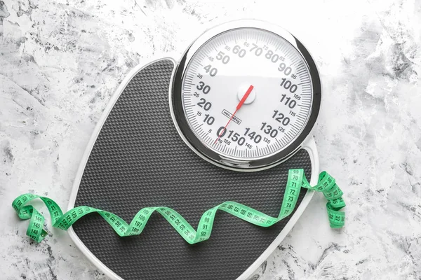 Scales and measuring tape on light background. Weight loss concept — Stock Photo, Image