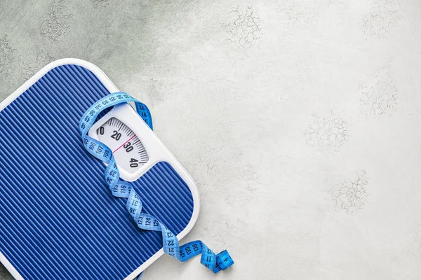 Scales and measuring tape on light background. Weight loss concept — 스톡 사진
