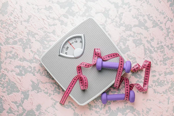 Scales, dumbbells and measuring tape on light background. Weight loss concept — 스톡 사진