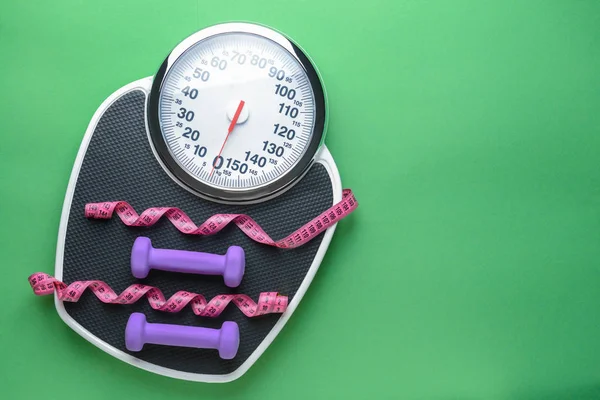 Scales, dumbbells and measuring tape on color background. Weight loss concept — Stock Photo, Image