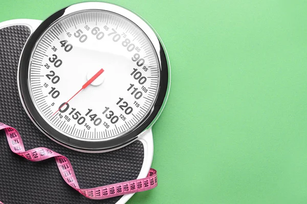 Scales and measuring tape on color background. Weight loss concept — 스톡 사진