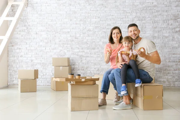 Happy family eating pizza on moving day — Stock Photo, Image
