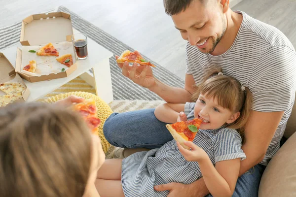 Šťastná rodina jíst pizzu doma — Stock fotografie