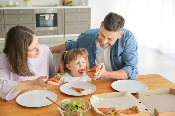 Família feliz comer pizza em casa — Fotografia de Stock