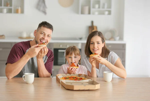 Šťastná rodina jíst pizzu doma — Stock fotografie