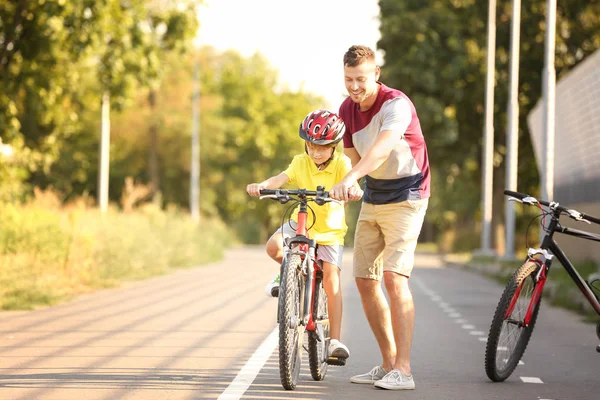 Pai ensinando seu filho a andar de bicicleta ao ar livre — Fotografia de Stock