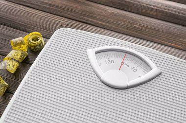 Tahta arka plandaki mezura ve mezura, yakın plan. Kilo verme konsepti