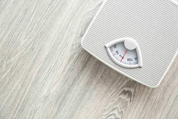 Floor scales on wooden background