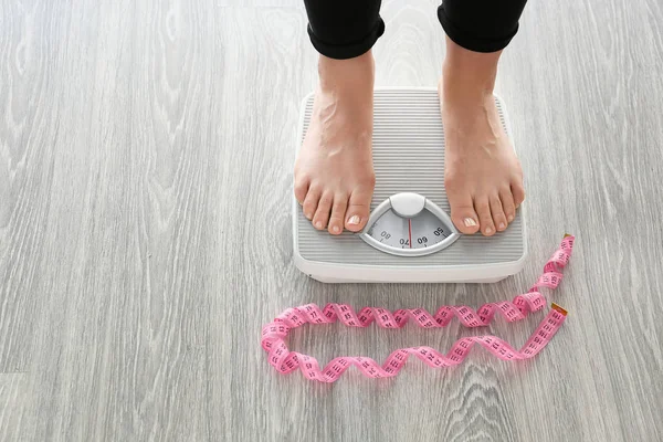 Woman standing on scales. Weight loss concept