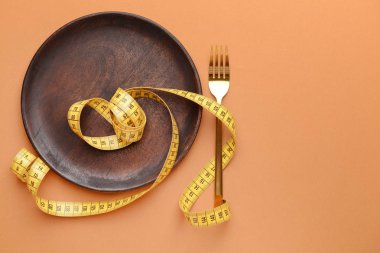 Çatal, plaka ve mezura ile renk arkaplanı. Diyet kavramı