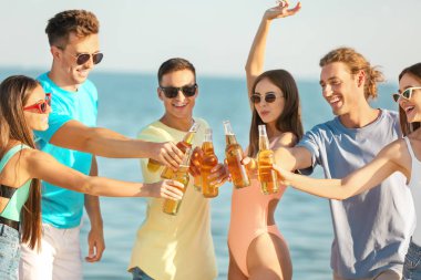 Arkadaşlar deniz plajında bira içiyor