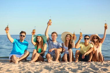 Arkadaşlar deniz plajında bira içiyor