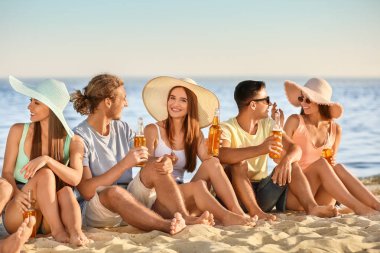 Arkadaşlar deniz plajında bira içiyor