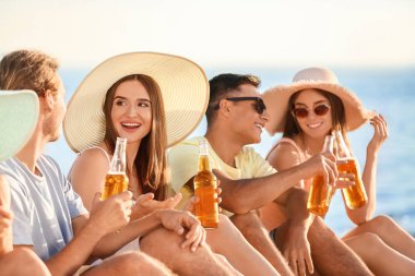 Arkadaşlar deniz plajında bira içiyor