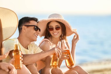 Arkadaşlar deniz plajında bira içiyor