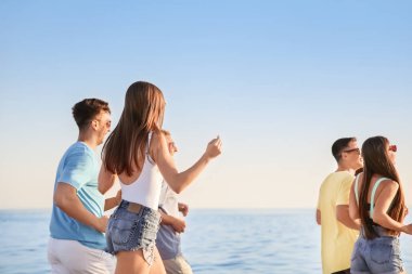 Dostlar sahilde koşuyor.