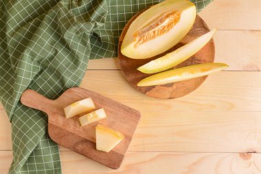 Masanın üzerinde olgun kavun dilimleri olan kompozisyon