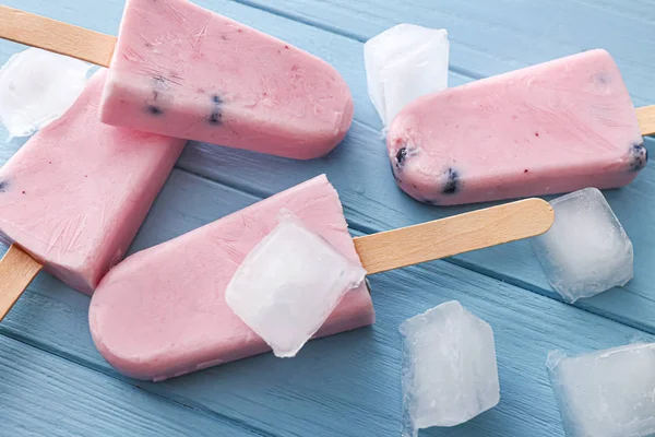 Tasty blueberry ice cream with ice cubes on wooden table — Stock Photo, Image
