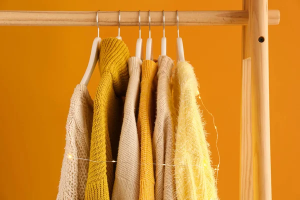 Rack with winter clothes on color background — Stock Photo, Image