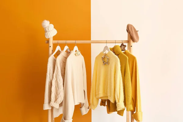 Rack with winter clothes on color background — Stock Photo, Image