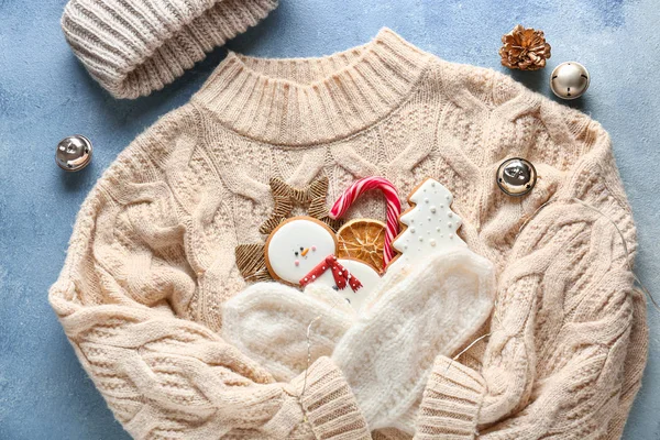 Gebreide trui met muts en kerstdecor op kleur achtergrond — Stockfoto